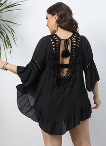 Detail of crochet hollow-out back with fringe tassels on black beach cover-up top