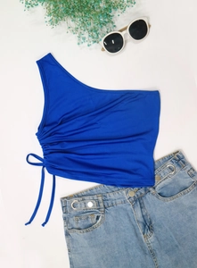 Detail of royal blue one-shoulder crop top featuring adjustable side drawstring and ruched texture