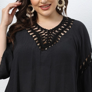 Close-up of black crochet lace neckline and openwork hollow details on beach cover-up