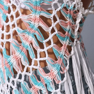 Detailed view of handmade crochet boho beach cover-up with colorful knit fringe