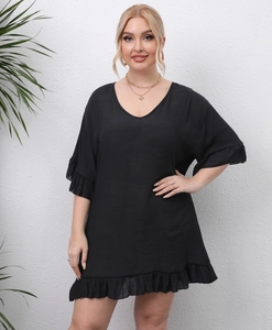 Detail of plus size black beach dress with ruffled hem and V-neckline texture