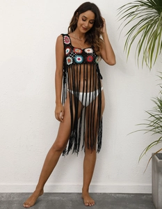 Détail d'un cache-maillot bohème au crochet avec motifs floraux colorés et longues franges noires
