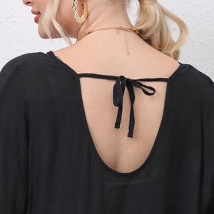 Detailed back view of a black beach dress featuring a deep V-cut and stylish bow tie lace-up