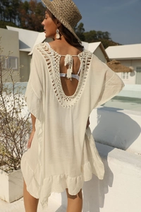 Dettaglio vestito da spiaggia boho bianco con uncinetto traforato, schiena nuda e volant