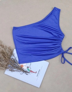 Close-up of royal blue one-shoulder crop top with adjustable side drawstring ruching