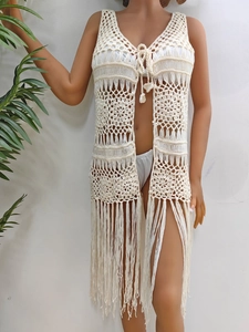 Détail du motif ajouré en crochet avec pompons sur ce cache-maillot de plage beige