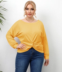 Detail of plus size ginger yellow top featuring a unique front knot and boat neck design