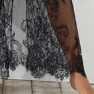 Gros plan d'un cardigan en dentelle noire avec motifs floraux et bordure en dentelle