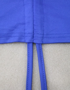 Close-up of royal blue cropped top with adjustable drawstring and double stitching details