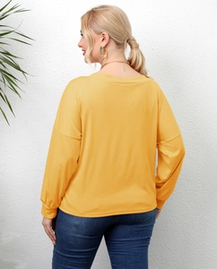 Detail of plus size yellow long sleeve top showing draped fit and soft cotton blend fabric