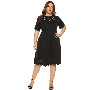 Detailed close-up of intricate laser-cut floral patterns on black plus size dress fabric