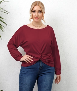 Detail view of the twist-knot hem on this wine red plus size long sleeve casual top
