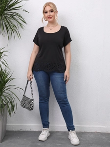 Detail of laser-cut hollow pattern on the hem of a black plus size short sleeve t-shirt