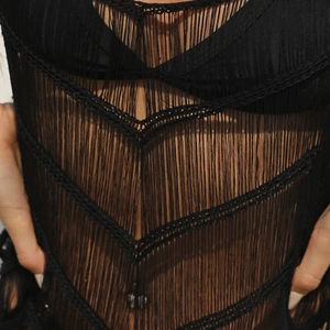 Détail de la texture des franges noires crochetées et motif de tricot sur la robe de plage