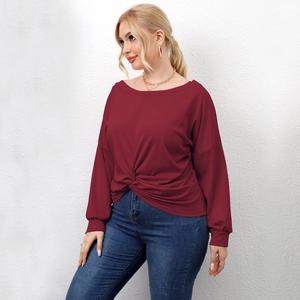 Detail of burgundy long sleeve top with stylish twisted hem design and boat neckline
