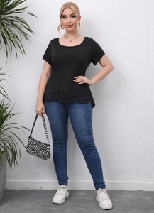 Close-up of the intricate laser-cut floral pattern on the hem of a black plus size T-shirt
