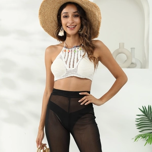 Close-up of white crochet halter top with colorful tassels and ethnic embroidery details
