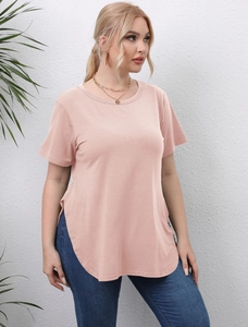 Detail of the high-low curved hem and side slit on a loose peach crewneck T-shirt