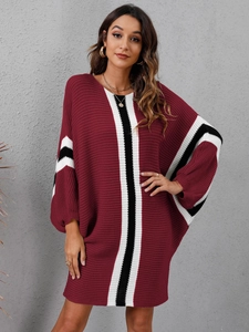 Detail of burgundy knit dress featuring batwing sleeves and striped contrast cuffs