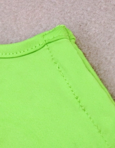 Close-up of neon green knit fabric showing detailed stitching and premium texture quality