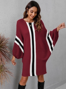 Detail of burgundy knit dress with black and white stripes and batwing sleeve design