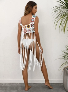 Détail d'un cache-maillot au crochet avec motifs floraux et longues franges blanches