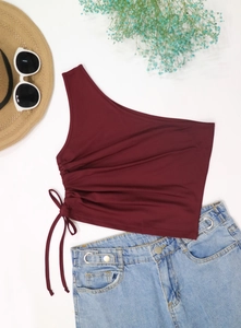 Detail view of wine red one-shoulder crop top with adjustable drawstring and side ruched texture
