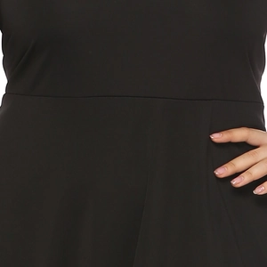 Detailed macro view of black high-waisted dress featuring pleated side seam stitching