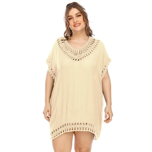 Detail of crochet hollow lace embroidery on beige V-neck beach cover up dress