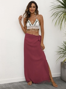 Detail of burgundy wrap sarong skirt with playful pom-pom fringe and side tie closure