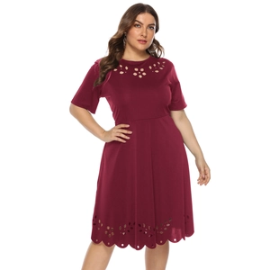 Detail of laser-cut floral cutouts and scalloped hem on a wine red short sleeve dress