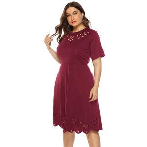Detail view of burgundy maxi dress with intricate laser-cut floral patterns and scalloped hem