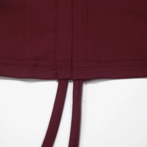 Macro shot of wine red crop top featuring double-needle stitching and drawstring hem detail