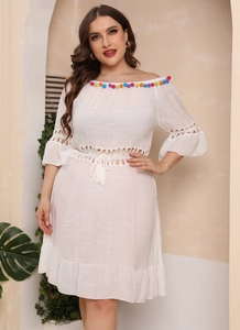 Detail of white off-shoulder beach dress with colorful tassels and lace hollow embroidery