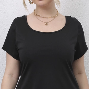 Detail of the round neckline on a black short sleeve top with layered gold necklace