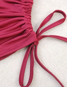 Detail of burgundy drawstring crop top with adjustable ruched fabric and fine stitching