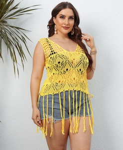 Detail of bright yellow crochet tank top with bohemian hollow patterns and long fringe tassels