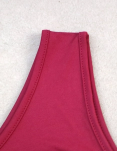 Close-up of double-stitched seams and elastic rose red fabric on this cropped top