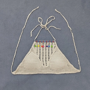 Detail of crochet bikini top with colorful pom-poms and hand-knitted hollow pattern