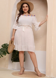 Detail of white off-shoulder beach dress with colorful pompoms and lace crochet