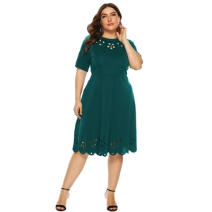 Close-up of laser-cut floral hollow patterns on the hem of a dark green plus size dress