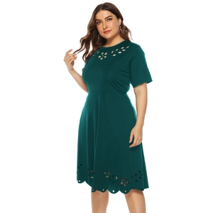 Detail of dark green dress showing laser-cut floral patterns and premium knit texture