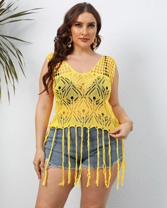 Close-up of bright yellow crochet beach cover-up with hollow patterns and long fringe