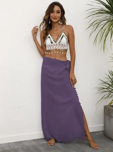 Detail of bohemian crochet halter top with shells and purple wrap skirt with tassels