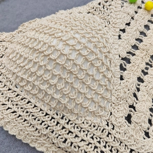 Detailed close-up of handmade crochet bikini top with bohemian knit patterns and pads