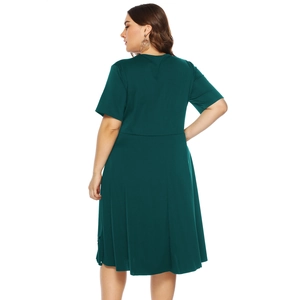 Side-back view of a dark green plus size A-line dress with short sleeves and high waistline