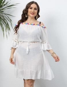 Detail of off-shoulder neckline with colorful pom-poms and delicate hollow lace stitching