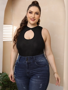 Detail of plus size black ribbed cutout top and high-waisted three-button blue jeans