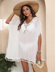 Détails du col en V au crochet blanc et franges bohèmes sur cette robe de plage