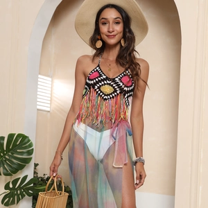 Dettaglio del top bikini all'uncinetto colorato con motivi floreali e nappe pendenti